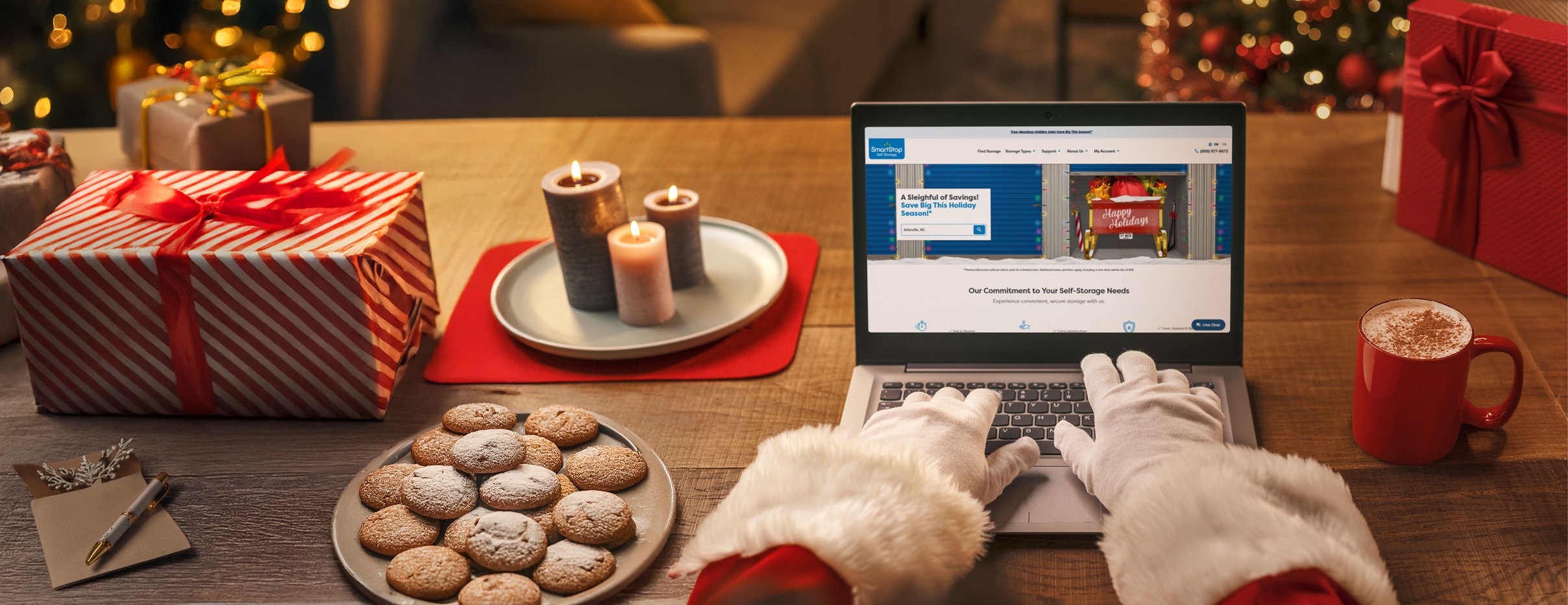 Image of person with a red suit and white gloves shopping on their computer for storage for their sleigh while enjoying some cookies and hot cocoa | SmartStop