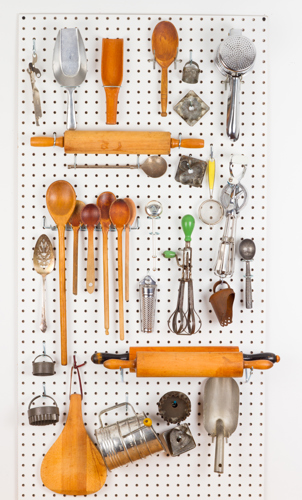 kitchen tools and utensils organized on a pegboard wall