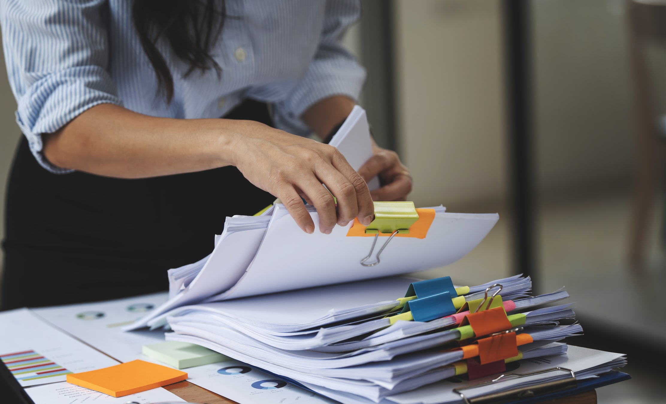 woman organizing stacks of papers