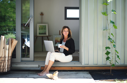 woman sitting in front of backyard container converted into home office