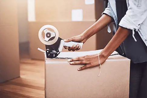 Image of a woman taping up a moving box