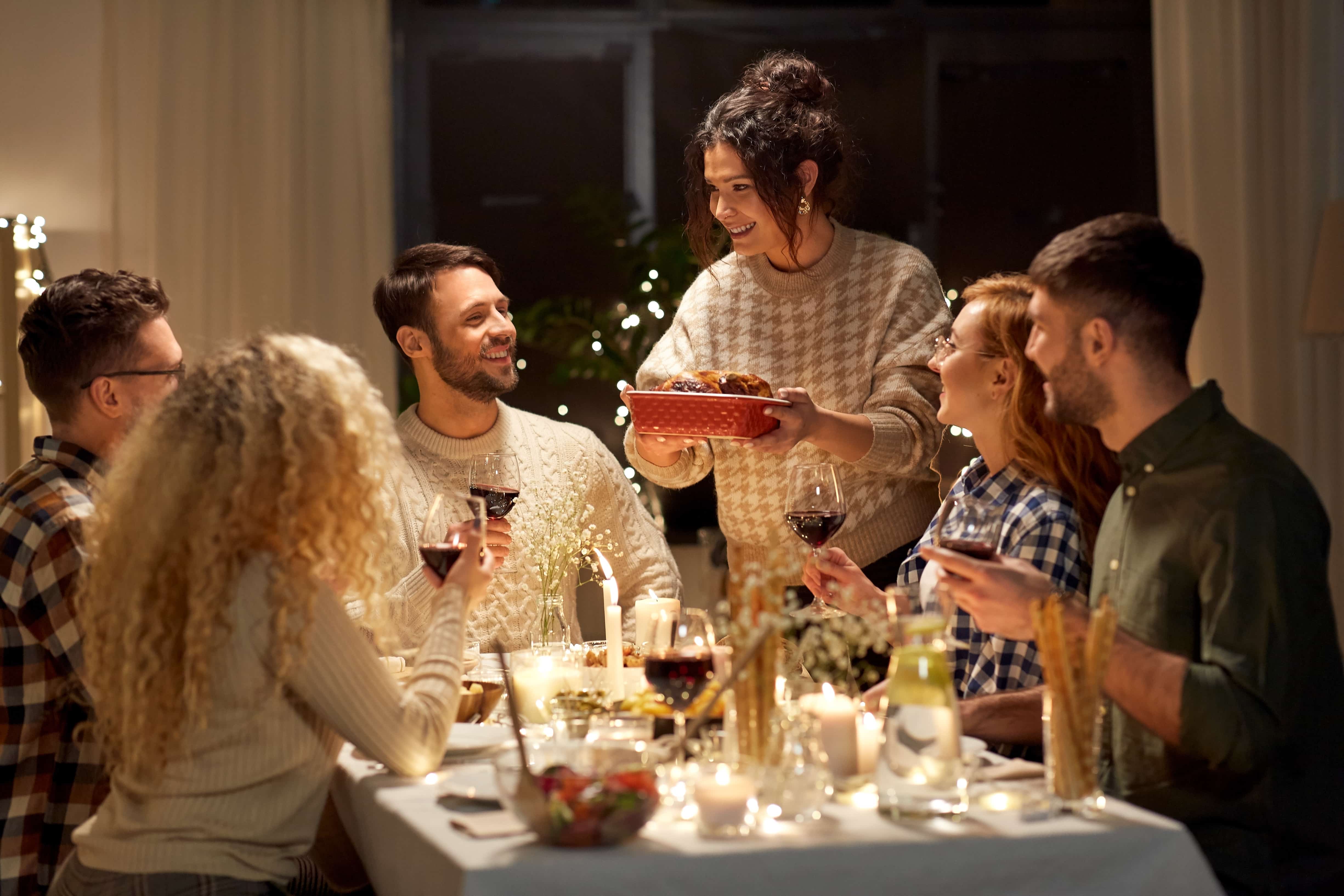 group of friends sitting around table for holidays
