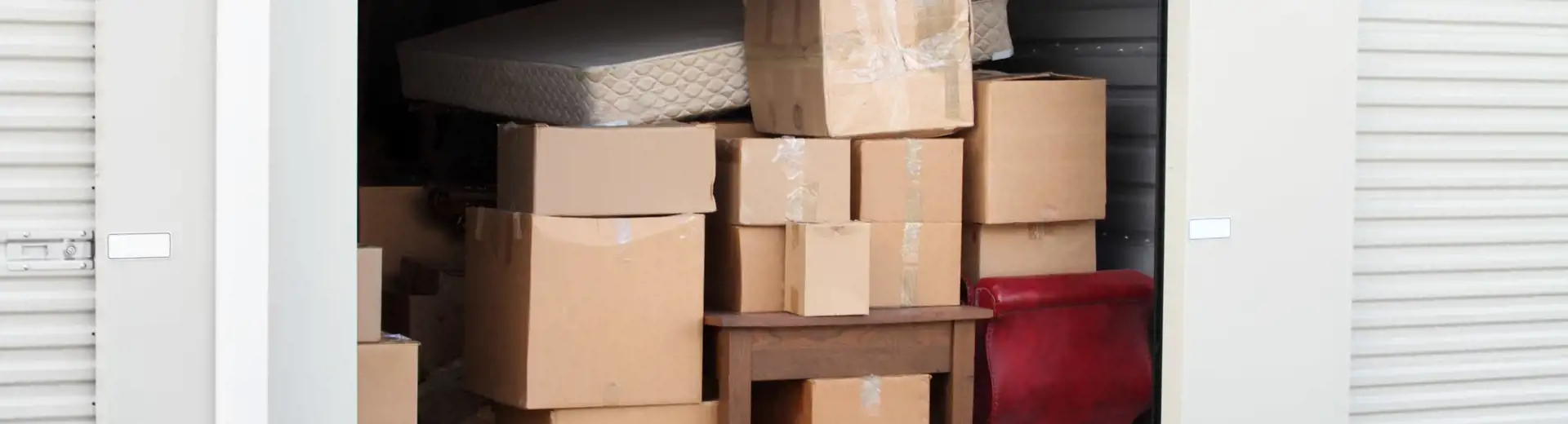 un entrepôt ouvert rempli de cartons, de meubles et de matelas