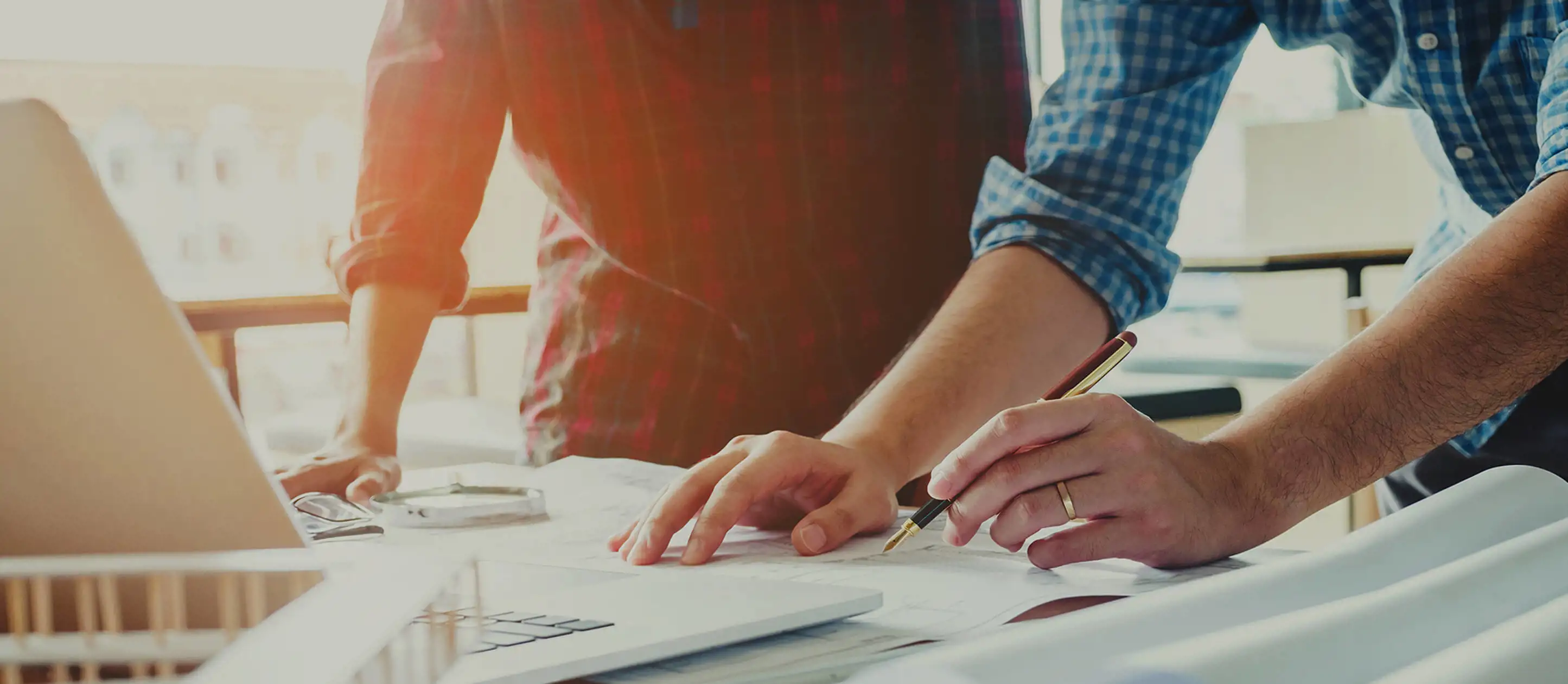Image of two people collaborating at a desk with a computer