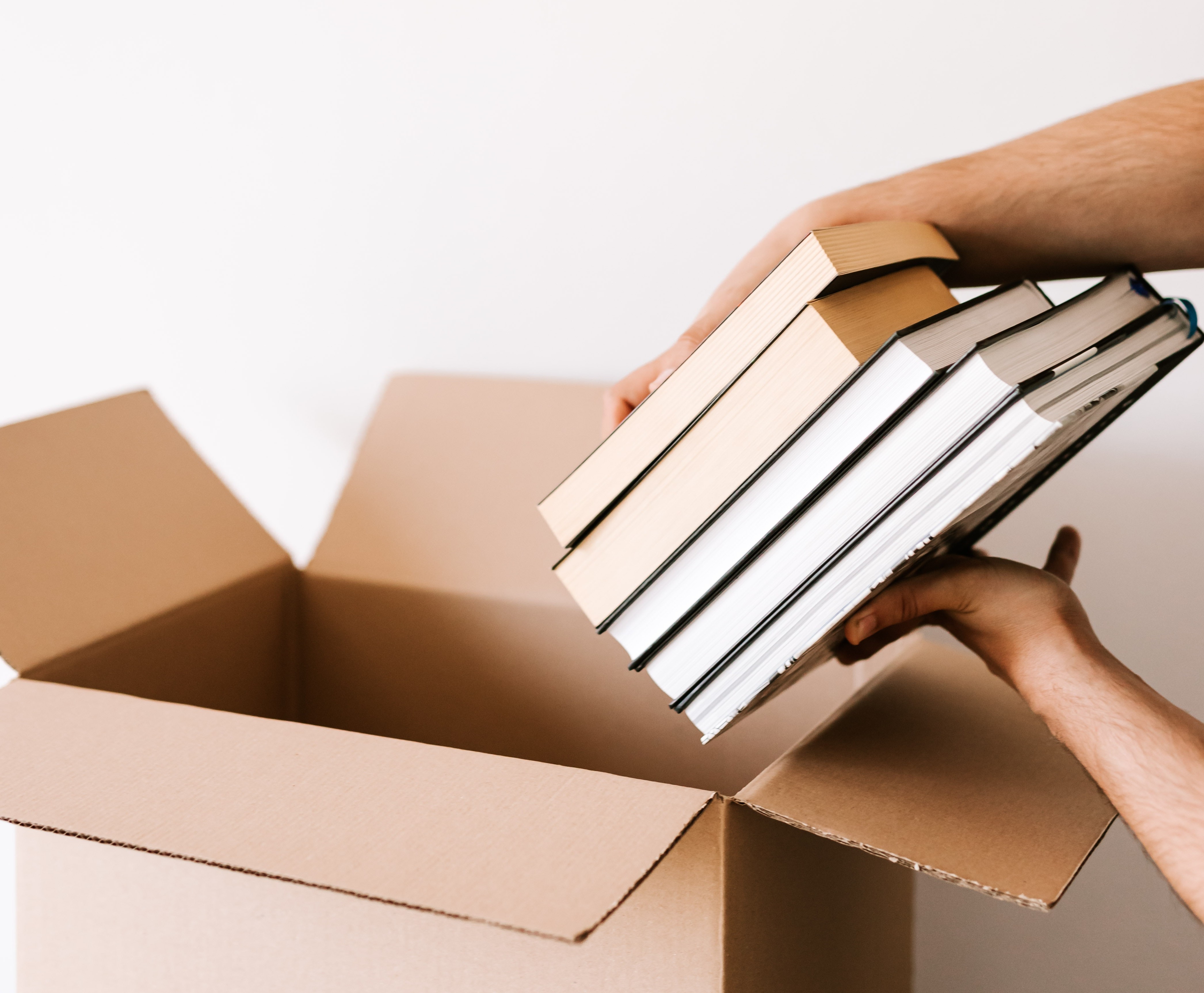 Un étudiant rangeant des manuels dans une boîte.