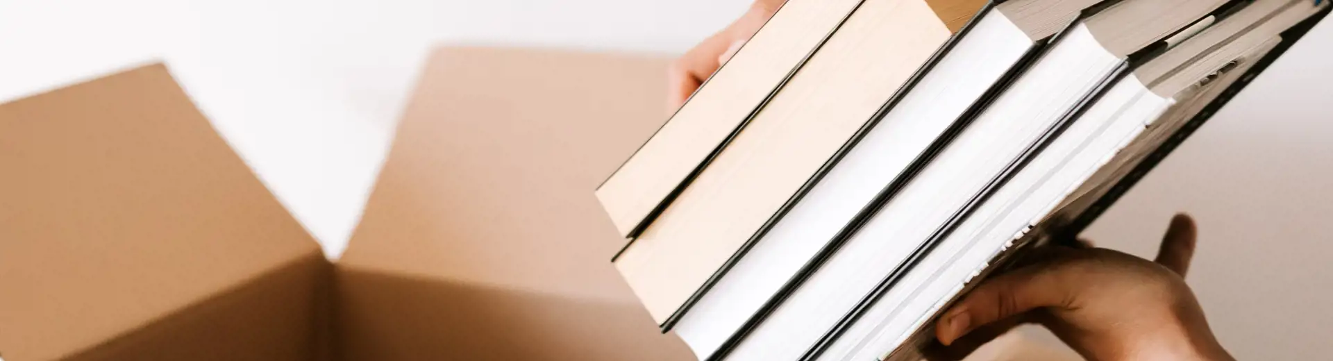 A student packing some textbooks into a box.