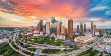 Image of Houston TX metropolitan skyline with orangey sunset sky
