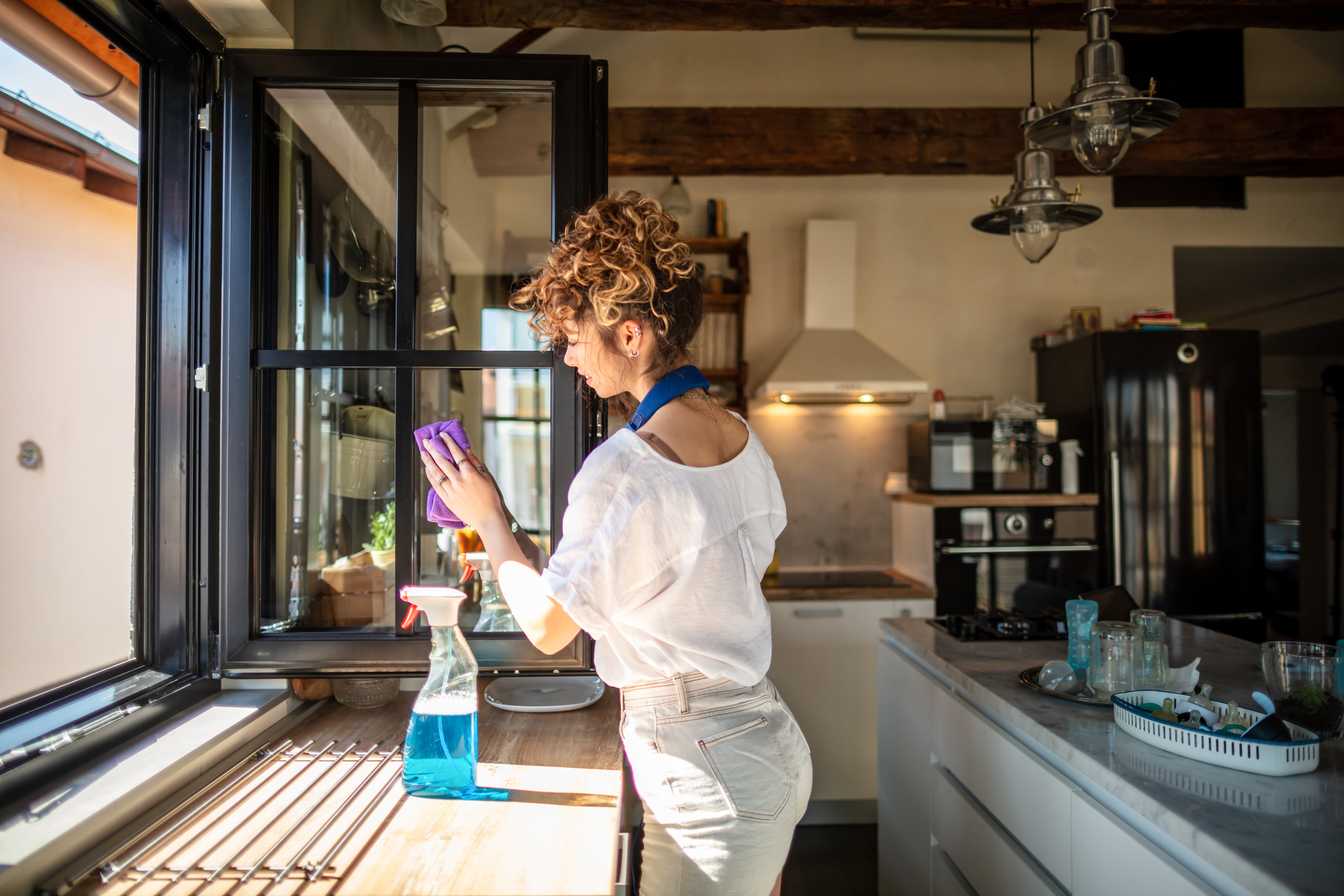 person cleaning window with microfiber cloth and diy glass cleaner solution