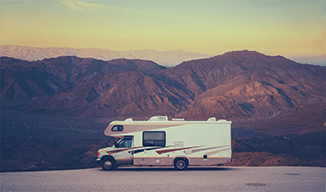 Image of recreational vehicle in the desert with a mountain backdrop