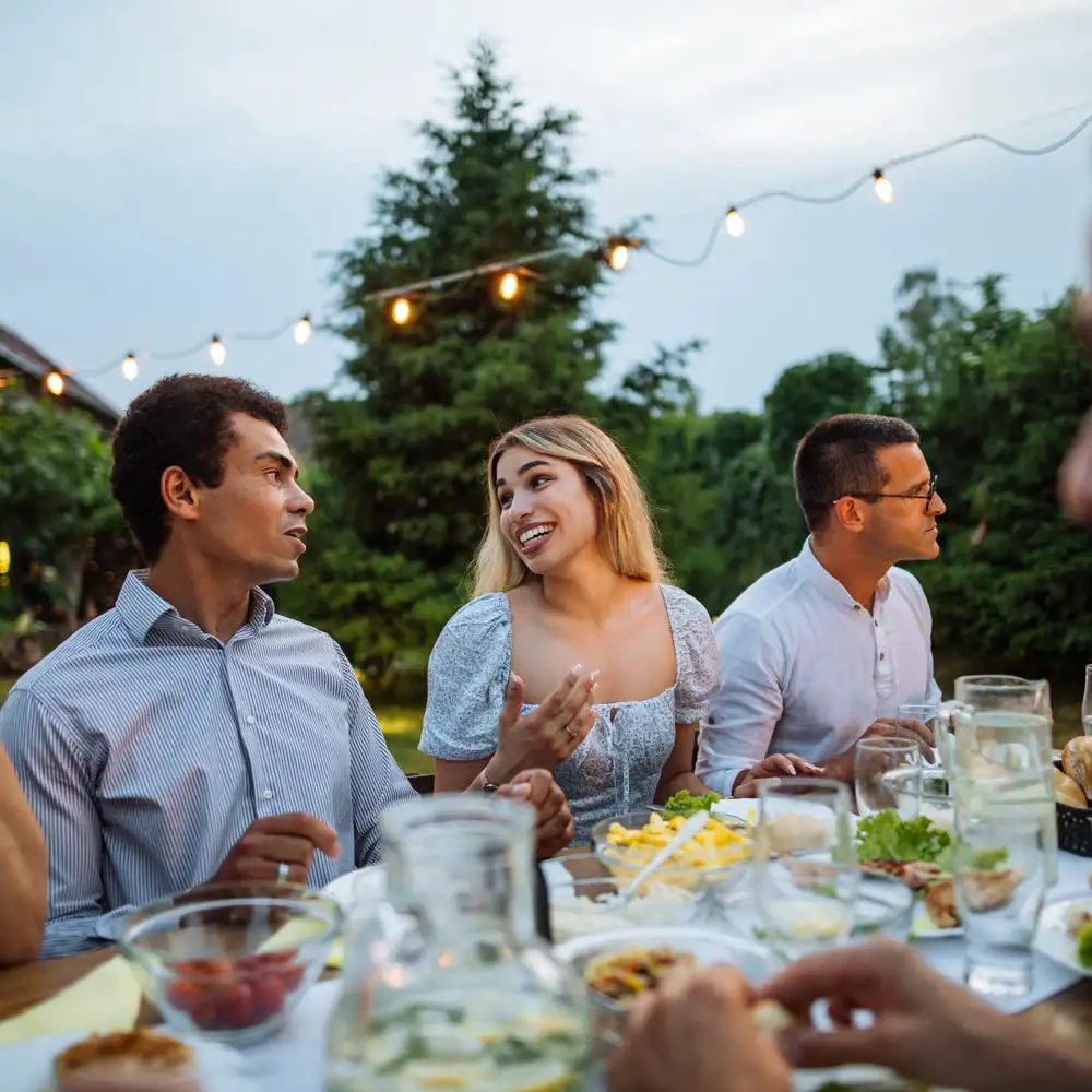 group of friends having outdoor summer backyard dinner