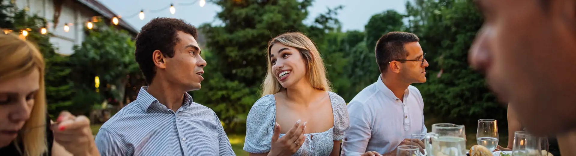 group of friends having outdoor summer backyard dinner