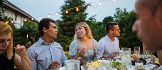 group of friends having outdoor summer backyard dinner
