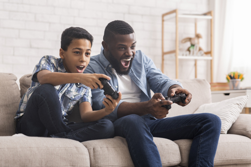 group of friends playing video games in a converted basement game room