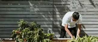man taking care of plants in backyard
