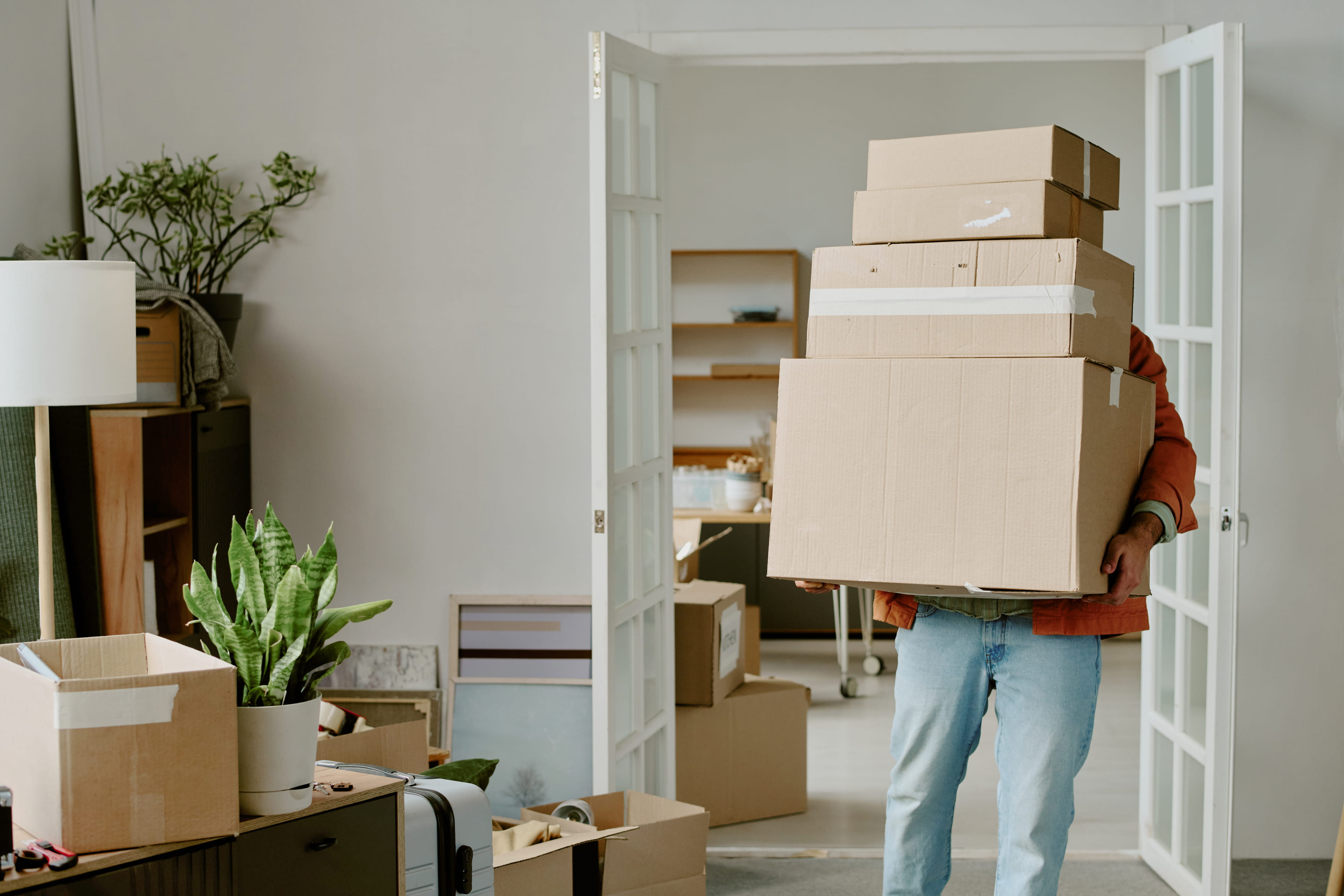 person carrying stack of cardboard moving and storage boxes