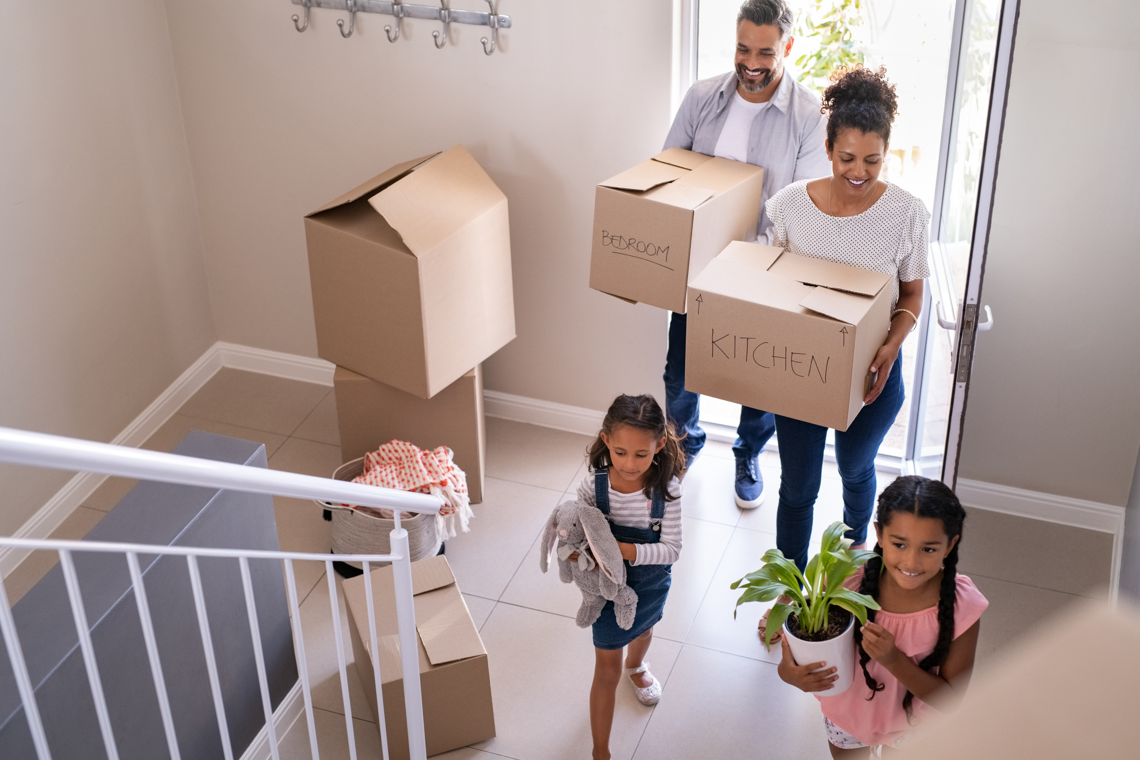 couple sitting on floor drinking coffee surrounded by moving boxes