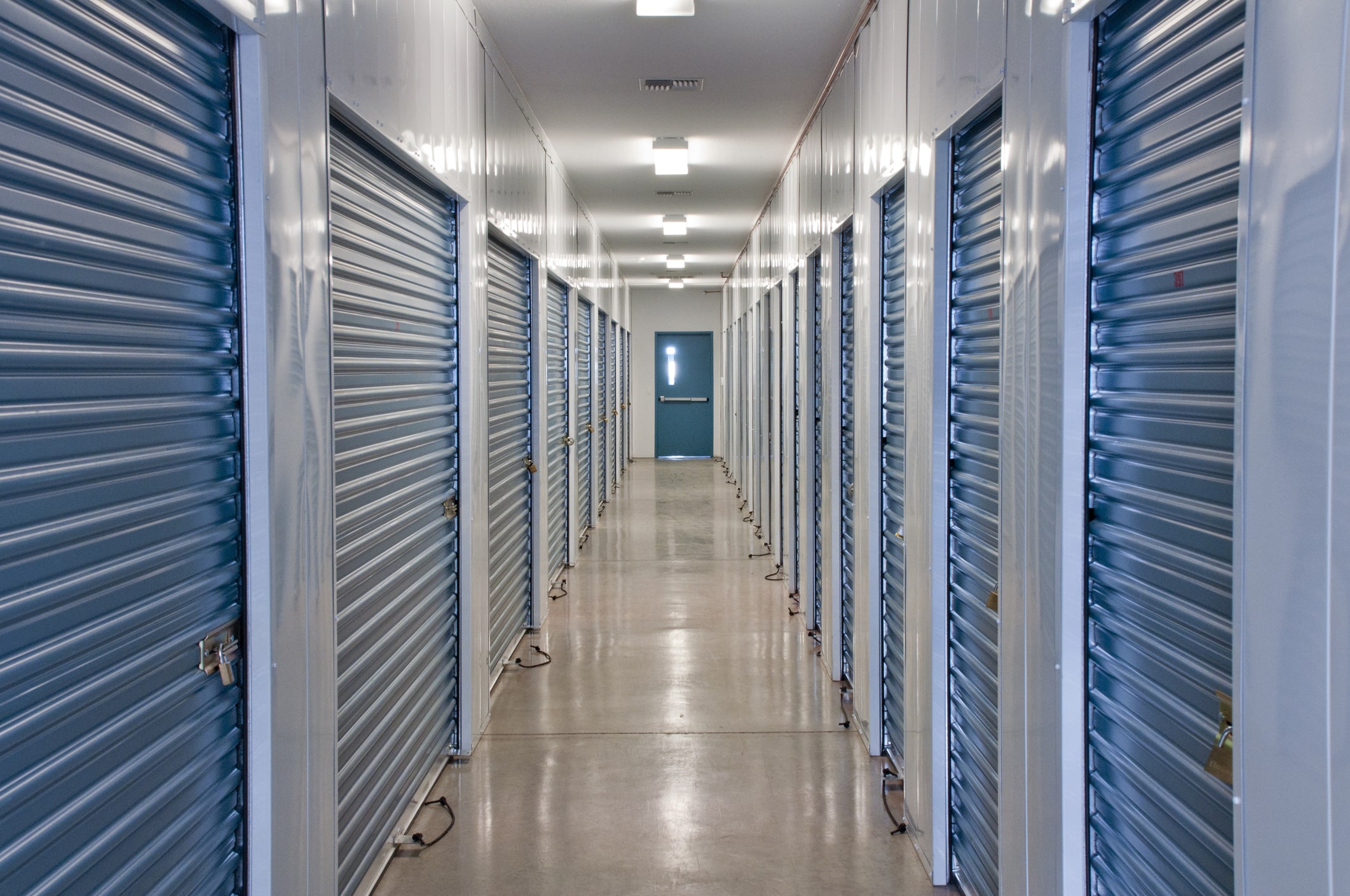 hallway inside of self-storage unit with blue metal doors