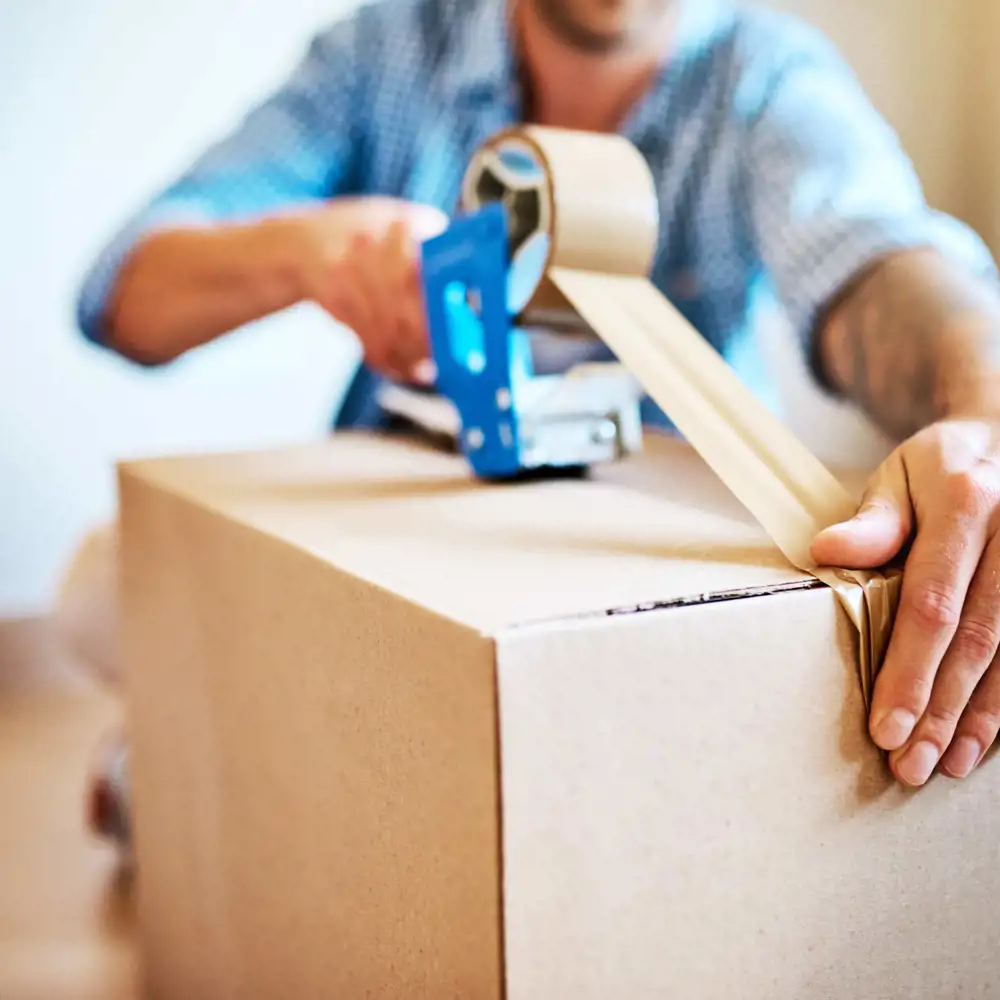 man taping moving box shut