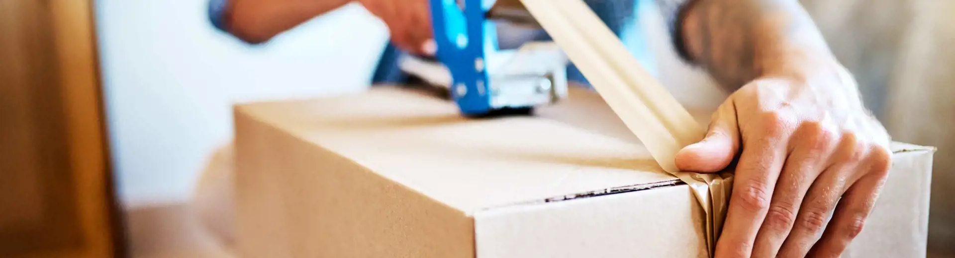 man taping moving box shut