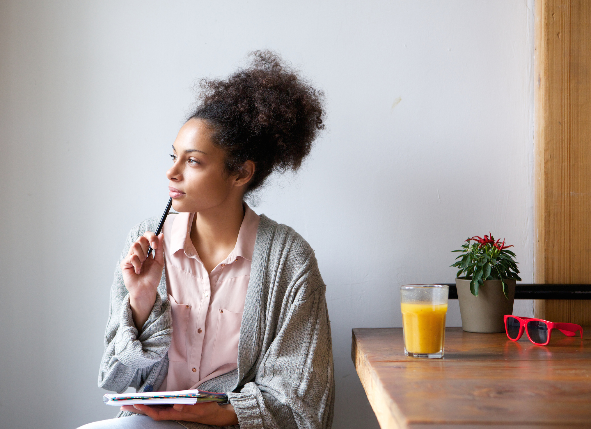 femme réfléchissant avec un stylo et un bloc-notes