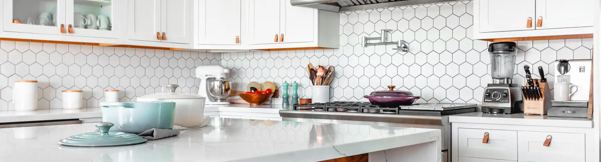well-lit kitchen with breakfast nook, white counters, tile, and cabinets.