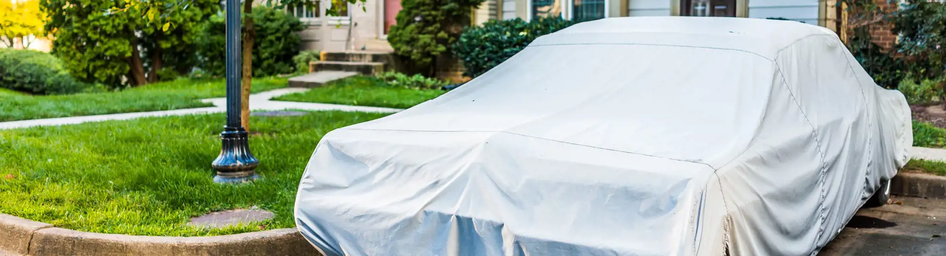 covered car parked in front of house