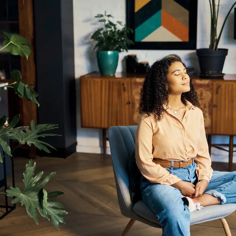 woman meditating while sitting on chair