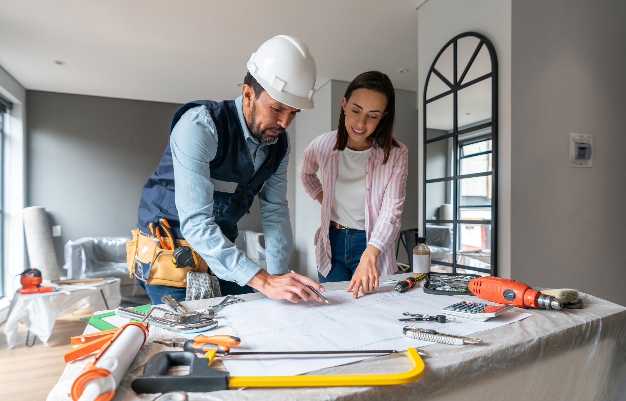 Femme discutant avec un ouvrier de la construction au sujet de la rénovation d'une maison
