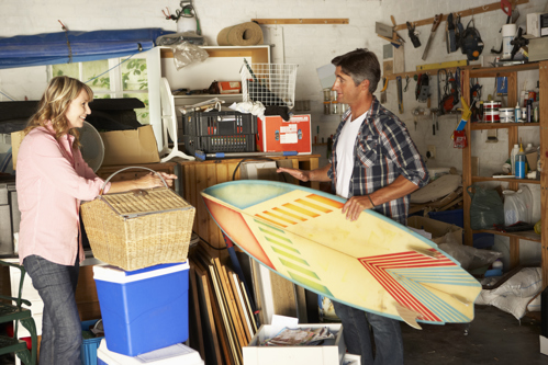 Couple in their garage organizing the items they store there.