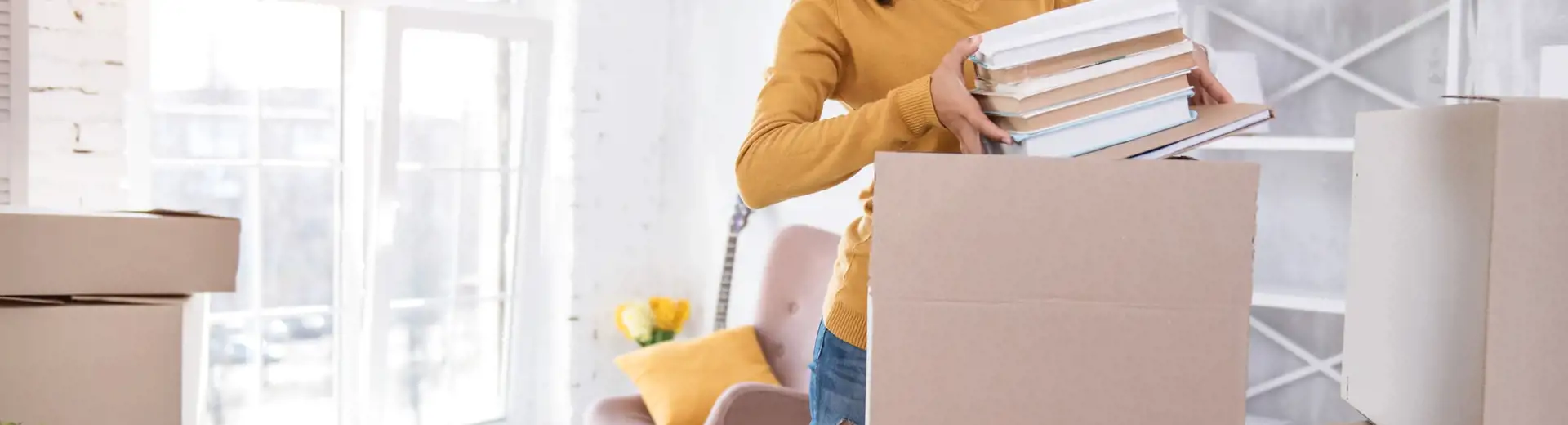 étudiant emballant des livres dans une boîte