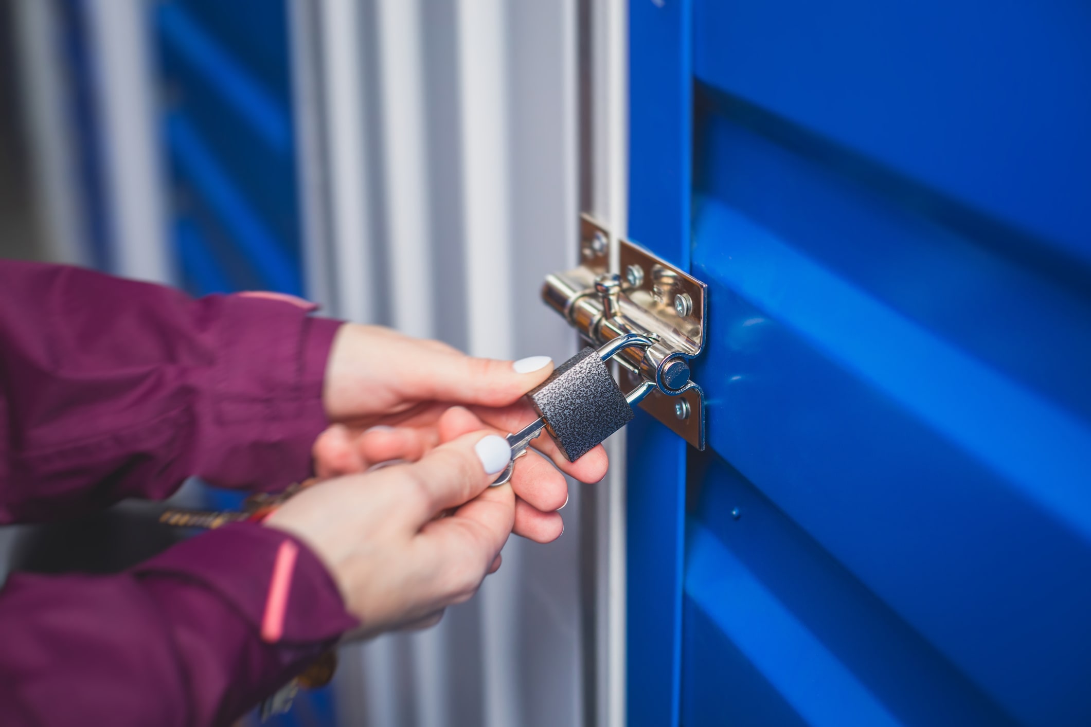 person inserting key into lock on self-storage unit door