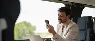 man working on laptop on commuter train