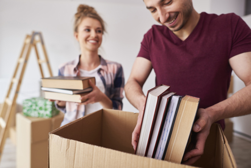 couple packing books in boxes to ship