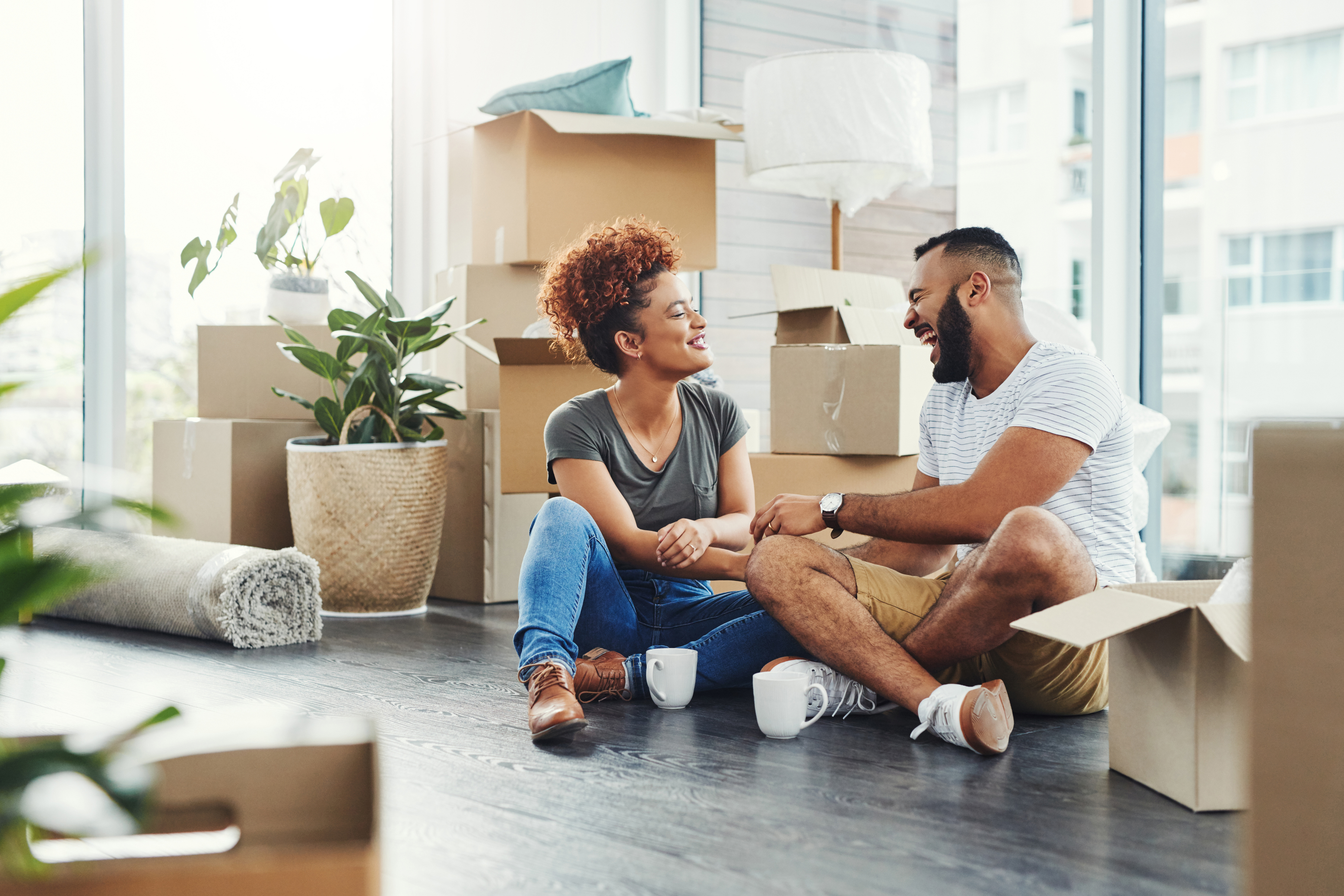 couple sitting down for a break while in the process of packing and moving