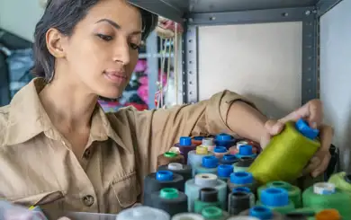 Image of woman looking through her sewing hobby supplies | SmartStop