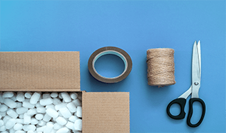 Image d'une boîte de carton, de ruban adhésif, de ciseaux et de ficelle