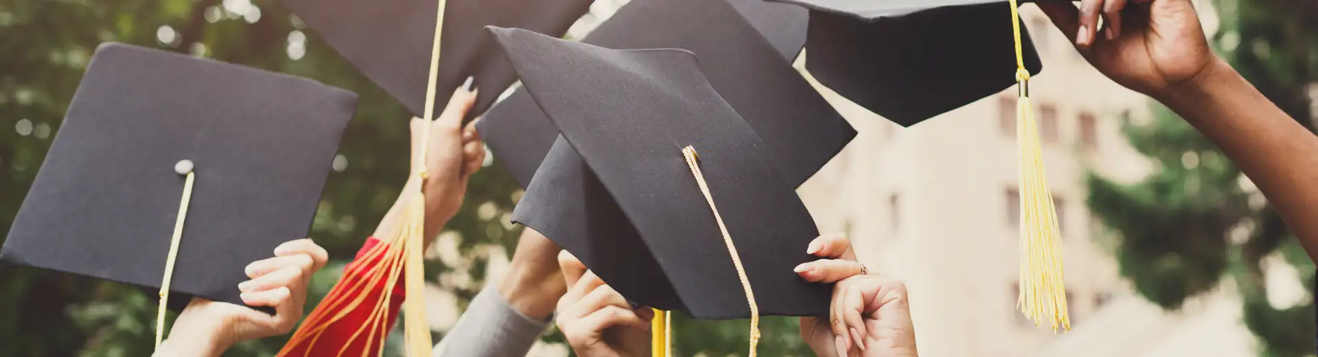 Image of new graduates throwing hands up into the air
