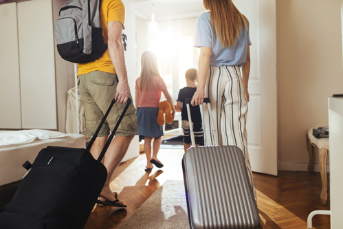 family walking into new home with their luggage