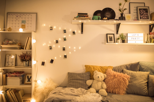 string lights hanging shelves and other decorations in teen bedroom