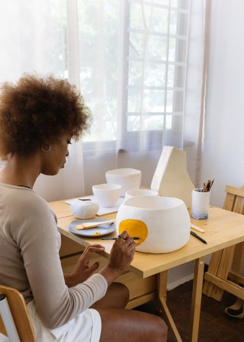 woman decorating pottery