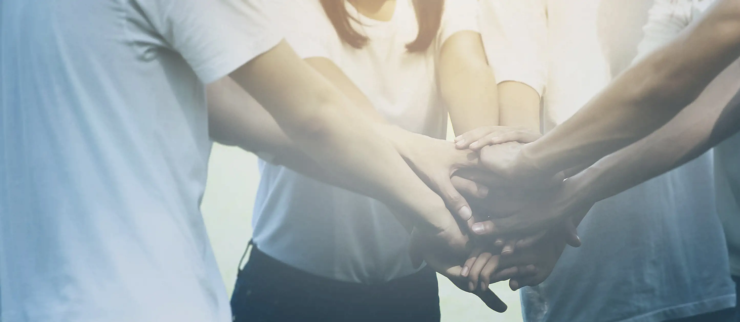 Image of group of people putting their hands together in unison