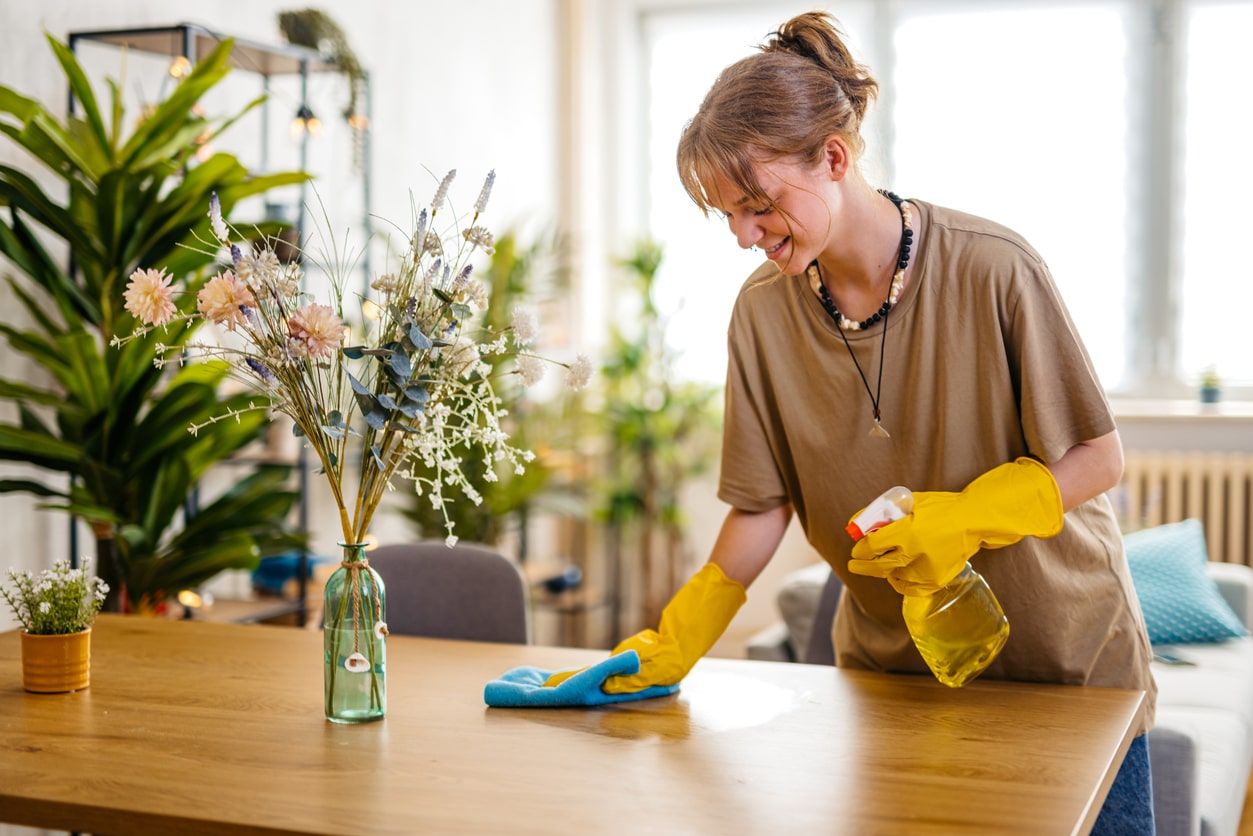 woman cleaning dining table surface