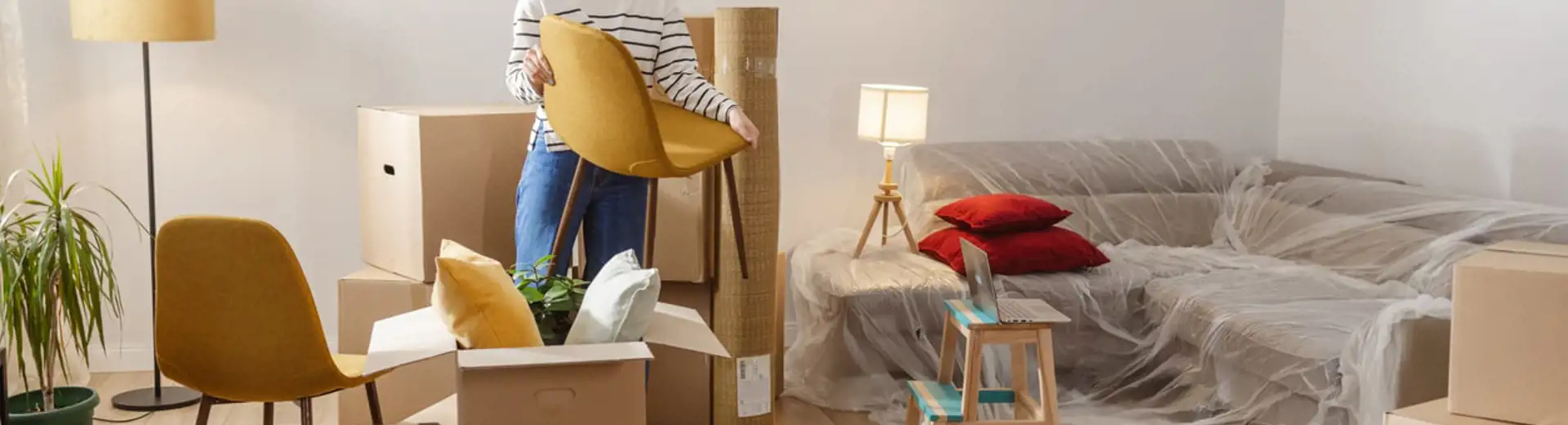 femme tenant une chaise alors qu'elle emménage dans un appartement