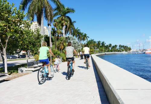 group of people biking along waterfront in west palm beach
