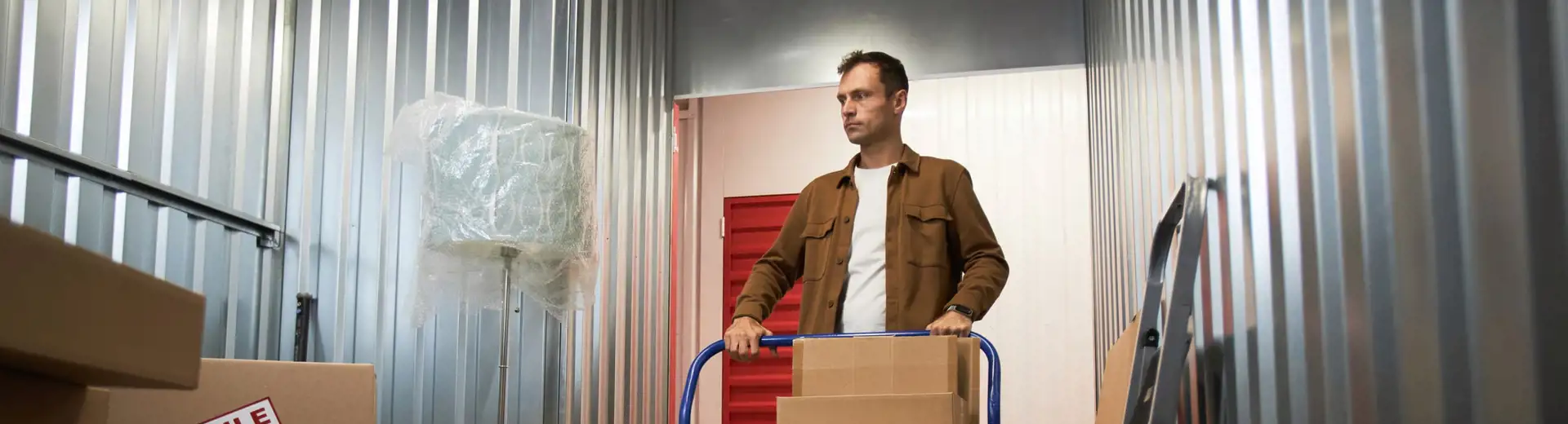 man moving box inside of storage unit