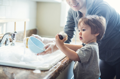 child helps cleaning dishes