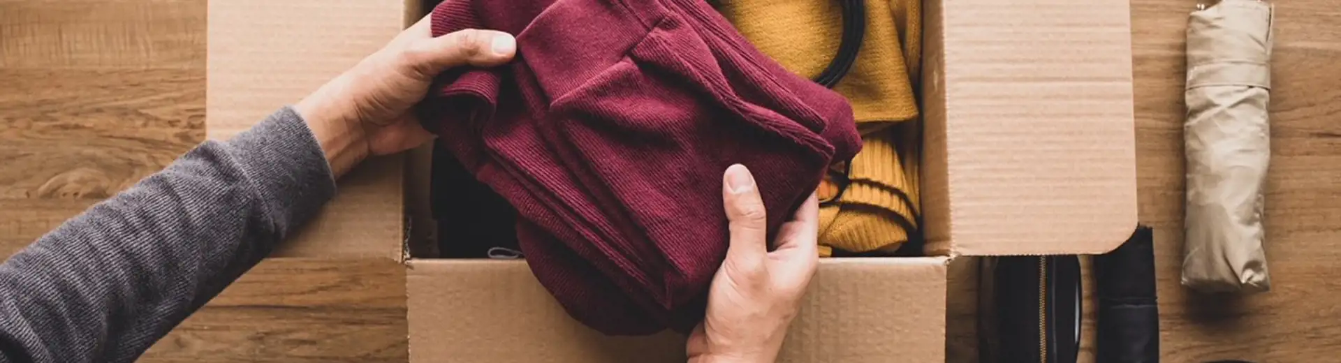 personne remplissant une boîte de vêtements