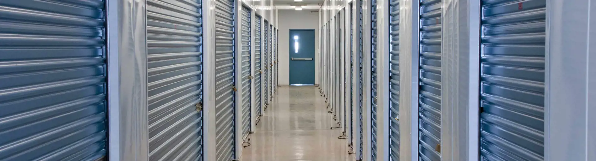 hallway inside storage facility with blue metal doors
