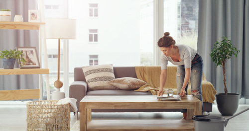 woman organizing books on coffee table