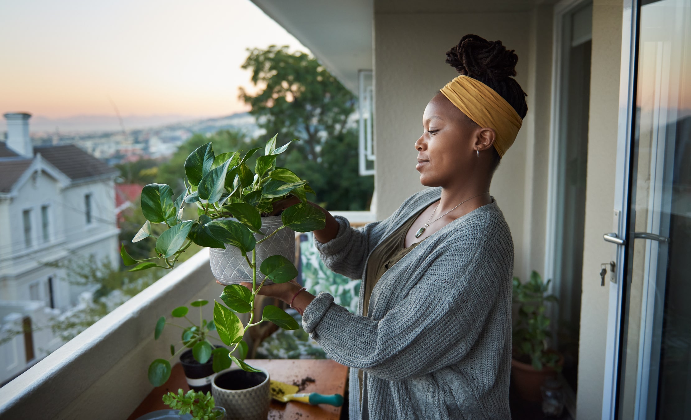 Femme rempotant une plante sur son balcon